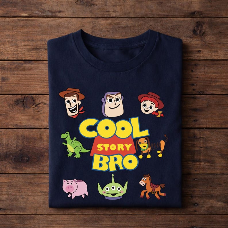Puede incluir: Camiseta azul marino con personajes de dibujos animados y el texto "COOL STORY BRO" en amarillo y blanco. El dise&ntilde;o incluye im&aacute;genes de un dinosaurio, un cerdo, un extraterrestre, un perro y un caballo.