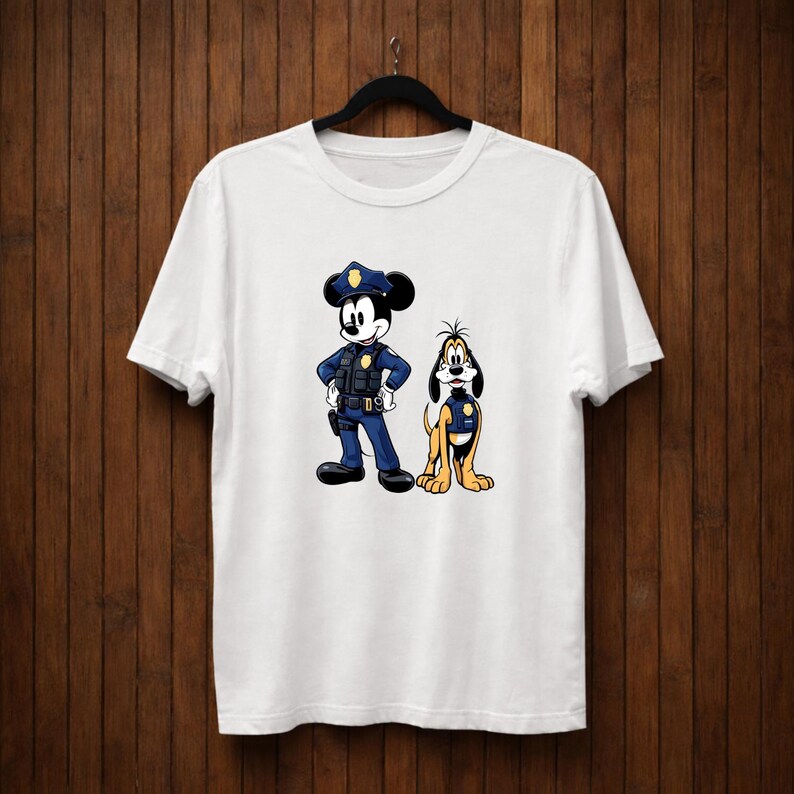 May include: White t-shirt featuring a cartoon illustration of Mickey Mouse and Pluto dressed as police officers. Mickey Mouse is in a blue uniform with a police hat, and Pluto is in a yellow uniform. The design is centered on the shirt.