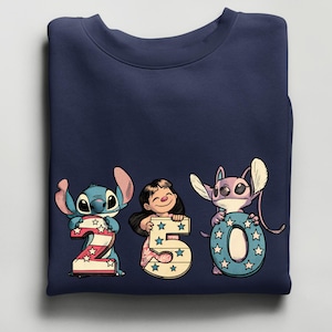 Puede incluir: Sudadera azul marino con personajes de dibujos animados que sostienen los n&uacute;meros 2, 5 y 0. Los n&uacute;meros est&aacute;n decorados con estrellas y rayas. Los personajes son Stitch, Lilo y Angel.