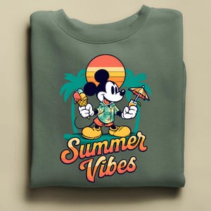 May include: Green sweatshirt featuring a cartoon Mickey Mouse holding an ice cream cone and a tropical drink. The design includes a sunset, palm trees, and the words "Summer Vibes" in orange and yellow.