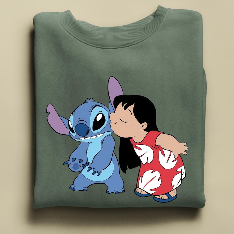 Peut inclure: Sweat-shirt vert sauge avec un motif de Stitch et Lilo du film Lilo & Stitch. Lilo embrasse Stitch. Stitch est bleu avec de grandes oreilles. Lilo porte une robe rouge &agrave; motifs de feuilles blanches. Design color&eacute; pour les fans.