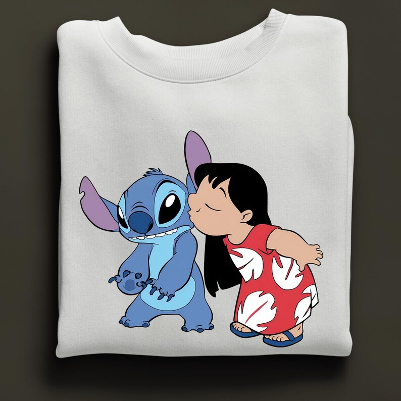 Peut inclure: Sweat-shirt blanc avec un dessin de Stitch, un extraterrestre bleu, embrass&eacute; par une fille en robe rouge. Le motif repr&eacute;sente les personnages du film d'animation Lilo & Stitch. Le sweat-shirt est un v&ecirc;tement confortable et d&eacute;contract&eacute;.