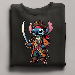 May include: Black sweatshirt featuring a cartoon character dressed as a pirate. The character is blue with large ears, wearing a brown pirate hat, coat, and boots, and holding a sword. The design is detailed with gold accents and a red bandana.