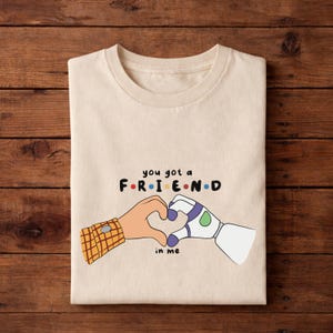 May include: A white ceramic mug with a black handle and the text "But First, Coffee" in a bold, black font. The mug is set against a neutral background, highlighting its simple design.