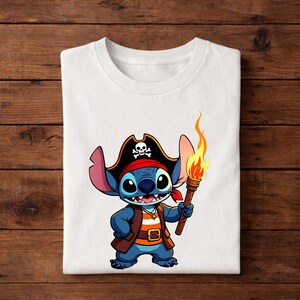 Pode incluir: Camiseta branca com um personagem de desenho animado pirata. O personagem azul tem olhos grandes e usa um chap&eacute;u de pirata com uma caveira, uma bandana vermelha e segura uma tocha com uma chama laranja. O design &eacute; centralizado.