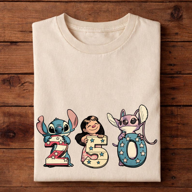 Puede incluir: Camiseta color crema con los personajes Stitch, Lilo y Angel sosteniendo los n&uacute;meros 2, 5 y 0. Los n&uacute;meros est&aacute;n decorados con estrellas rojas, blancas y azules, y los personajes son de estilo caricatura.