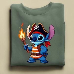 K&ouml;nnte beinhalten: Ein gr&uuml;nes Sweatshirt mit einer Cartoon-Figur als Pirat. Die blaue Figur tr&auml;gt einen Piratenhut mit Totenkopf, ein rotes Halstuch und ein orange-wei&szlig; gestreiftes Hemd. Die Figur h&auml;lt eine Fackel mit einer hellorangen Flamme.