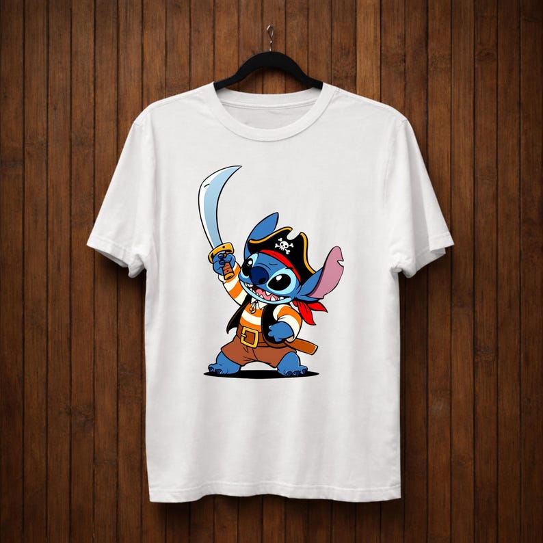 May include: White t-shirt featuring a cartoon character, Stitch, dressed as a pirate. Stitch is blue with large ears, wearing a pirate hat, vest, and holding a sword. The design is centered on the shirt.