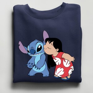 Peut inclure: Sweat-shirt bleu marine avec un dessin anim&eacute; de Stitch, un extraterrestre bleu, embrass&eacute; par Lilo, une jeune fille en robe rouge. Le motif est tir&eacute; du film Disney Lilo & Stitch.