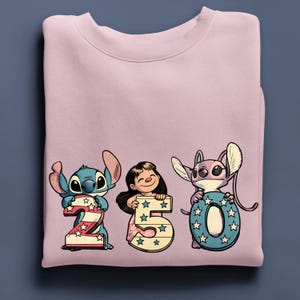 Puede incluir: Una sudadera rosa claro con los personajes de dibujos animados Stitch, Lilo y Angel sosteniendo los n&uacute;meros 2, 5 y 0. Los n&uacute;meros est&aacute;n decorados con estrellas y rayas, y los personajes son de estilo caricatura.