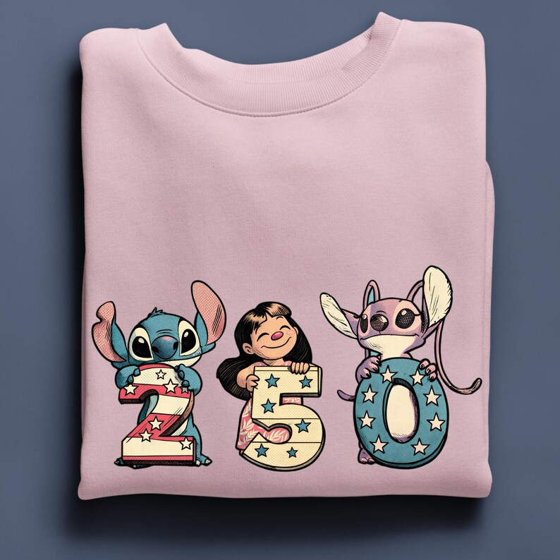 Puede incluir: Una sudadera rosa claro con los personajes de dibujos animados Stitch, Lilo y Angel sosteniendo los n&uacute;meros 2, 5 y 0. Los n&uacute;meros est&aacute;n decorados con estrellas y rayas, y los personajes son de estilo caricatura.