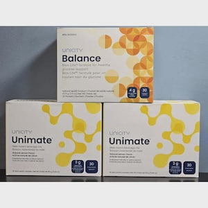 Puede incluir: Tres cajas de productos Unicity, incluyendo Balance y Unimate. Las cajas son blancas con gráficos y texto amarillos y naranjas. La caja Balance tiene 4g y 30 sobres. Las cajas Unimate tienen 3g y 30 sobres.