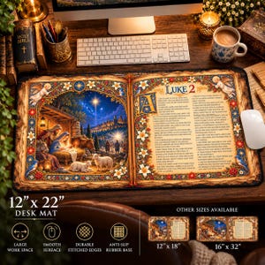 May include: A rectangular desk mat featuring a nativity scene illustration on the left and the text of Luke 2 on the right, framed by ornate floral borders. The mat measures 12 inches by 22 inches and has a smooth surface with stitched edges.