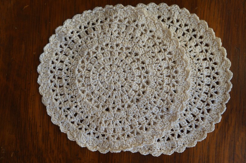 May include: Two white crocheted doilies with a delicate floral pattern.