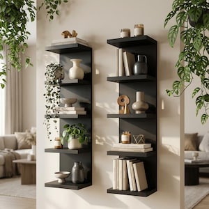 以下が含まれることがあります： 黒い壁掛け棚が2つあり、様々な装飾品が飾られています。各棚は5段で、本、花瓶、キャンドル、小さな彫刻が並んでいます。緑の植物が上から吊り下げられており、インテリアデザインに自然な要素を加えています。