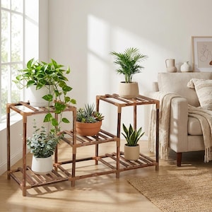 Peut inclure: Présentoirs à plantes en bois à plusieurs niveaux, avec des plantes en pot. Les présentoirs bruns sont dans un salon. Les plantes comprennent des pothos, des succulentes et des sansevières. Les présentoirs sont en bois.