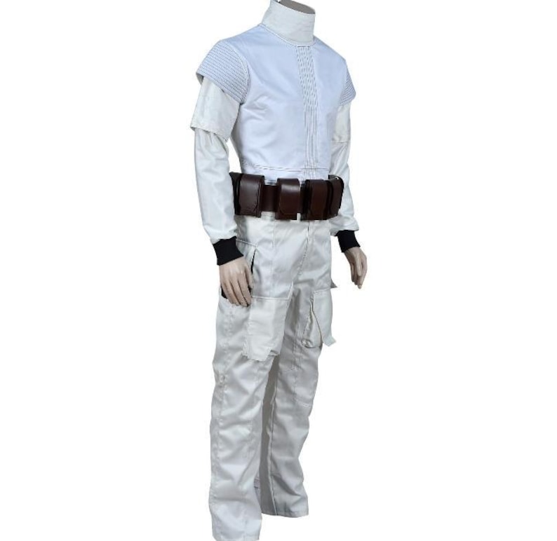 May include: A white costume with a high collar, short-sleeved jacket, and matching pants. The jacket has a pleated front and shoulder detailing. A brown belt with pouches is worn around the waist. Black cuffs are visible at the wrists.