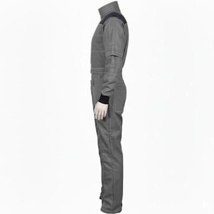 May include: A gray jumpsuit with a high collar and black accents on the shoulders and wrists. The one-piece garment has a fitted silhouette with visible seams and a front zipper. The sleeves have a layered design, and the overall style suggests a futuristic or technical aesthetic.