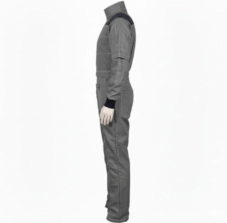 May include: A gray jumpsuit with a high collar and black accents on the shoulders and wrists. The one-piece garment has a fitted silhouette with visible seams and a front zipper. The sleeves have a layered design, and the overall style suggests a futuristic or technical aesthetic.