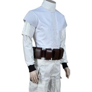 May include: White costume with a high collar, short sleeves, and a brown belt with pouches. The outfit has black cuffs and is likely for cosplay or a themed event. The fabric appears to be a smooth, possibly synthetic material.