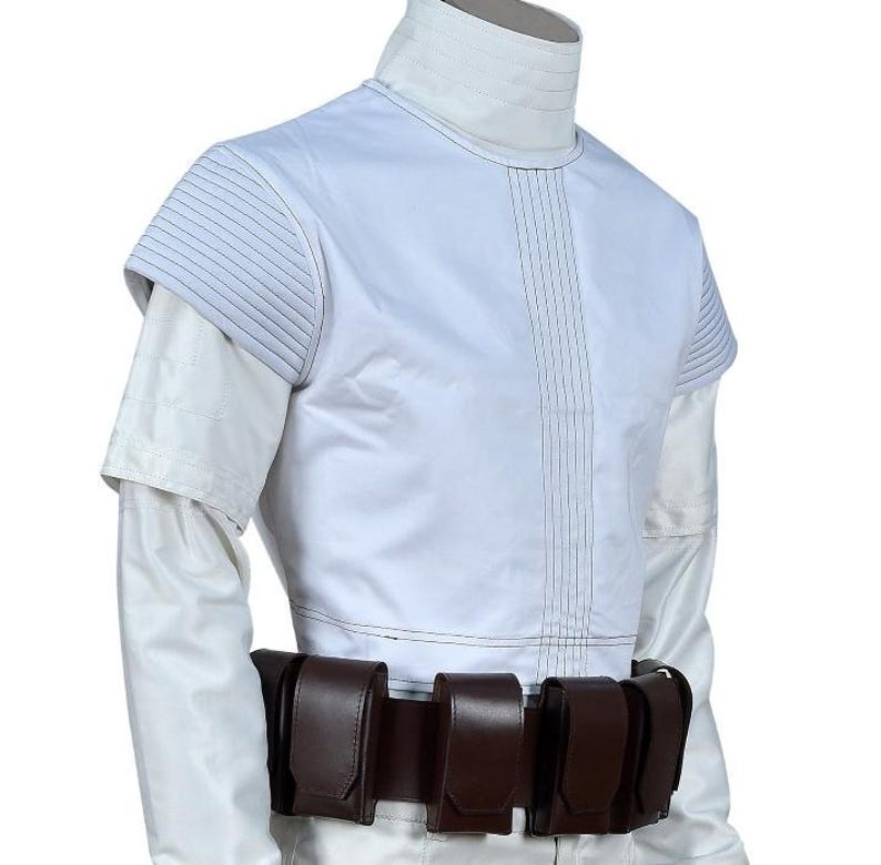 May include: A white costume with a high collar and short sleeves. The costume has vertical stitching down the front and quilted shoulder details. A brown belt with multiple pouches is worn around the waist.