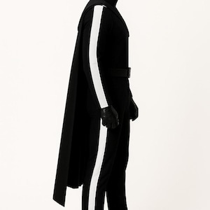 May include: A black full-body jumpsuit featuring a high collar, a long cape attached at the shoulders, and a prominent white vertical stripe running down the outer length of each arm and leg. The outfit includes a black belt, gloves, and boots.