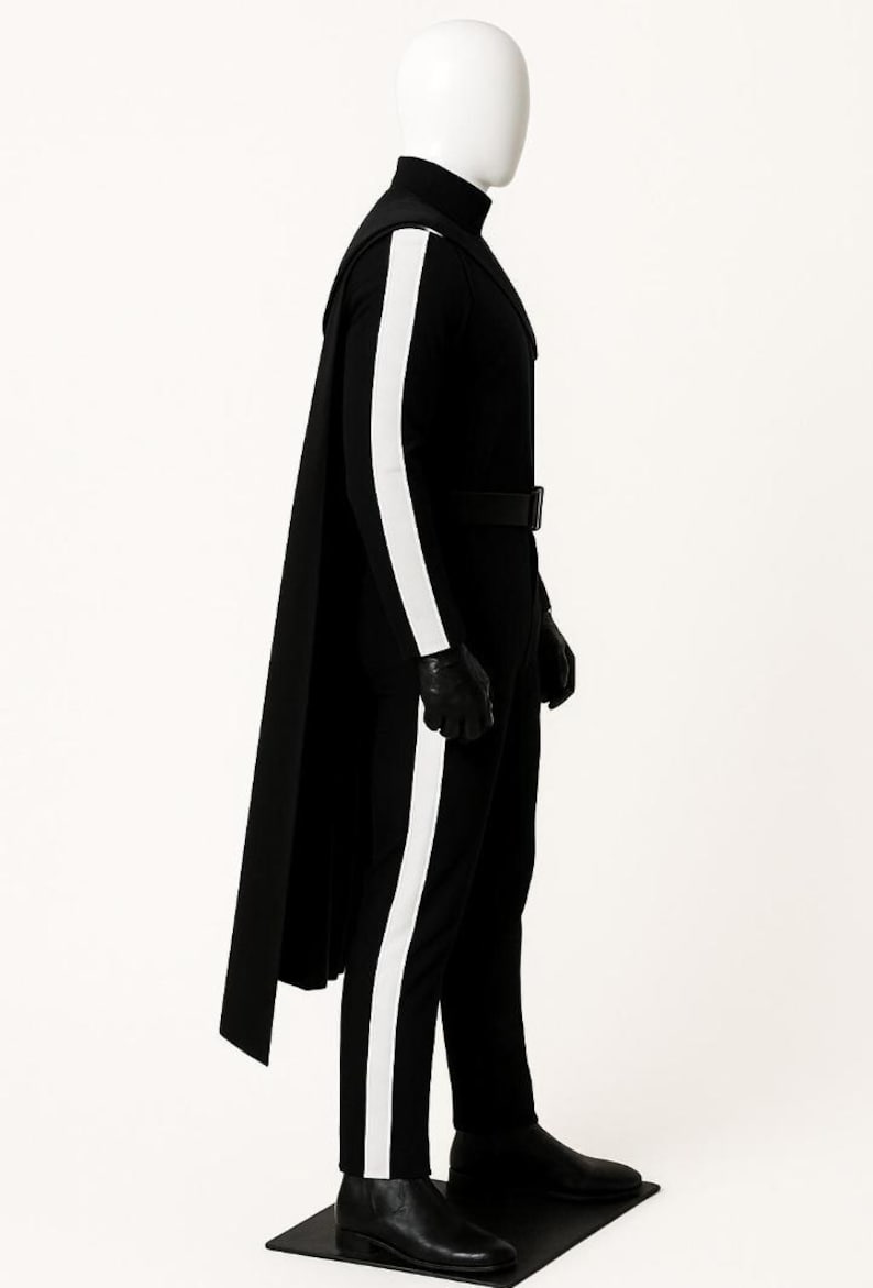 May include: A black full-body jumpsuit featuring a high collar, a long cape attached at the shoulders, and a prominent white vertical stripe running down the outer length of each arm and leg. The outfit includes a black belt, gloves, and boots.