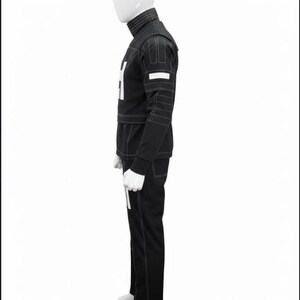 May include: A black long-sleeved jacket and matching trousers set featuring a high collar, white geometric accents on the chest and sleeves, and prominent white topstitching throughout the garment, displayed on a white mannequin torso.