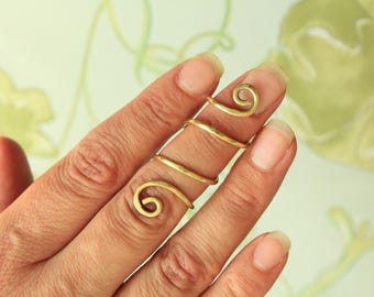 May include: A gold-toned metal finger splint featuring a continuous spiral design that wraps around the finger. The piece is constructed from a single smooth wire that forms a coil, providing support while maintaining a simple, open-ended structure.