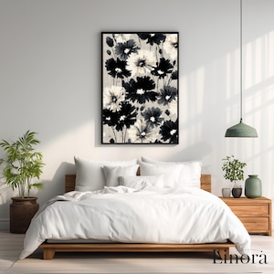 May include: A framed floral print with black and white flowers on a neutral backdrop. The artwork is displayed above a bed with white bedding and a wooden frame. The room is decorated with plants and a pendant light.