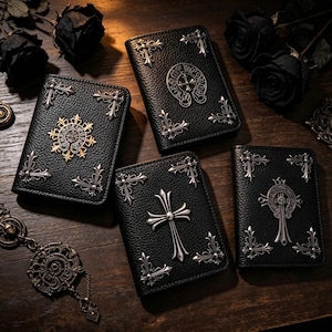 Puede incluir: Cuatro carteras de cuero negro con detalles decorativos plateados. Cada cartera presenta un diseño diferente, incluyendo cruces y patrones ornamentados. Las carteras están dispuestas sobre una superficie de madera oscura, con rosas negras en el fondo.