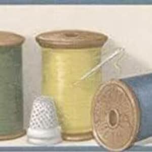 May include: A selection of sewing equipment, featuring thread spools in green, yellow, and blue, a thimble, and a needle. The spools have wooden ends. The thimble is white with a patterned design.