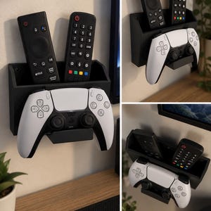 Op de afbeelding: Een zwarte wandorganizer met een rechthoekig vak voor het opbergen van twee afstandsbedieningen en een onderste houder voor een witte en zwarte draadloze gamecontroller. De unit wordt vanuit verschillende hoeken getoond.