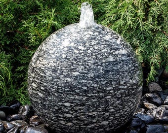 Fuente de piedra esférica de granito moteado con pulgar azul