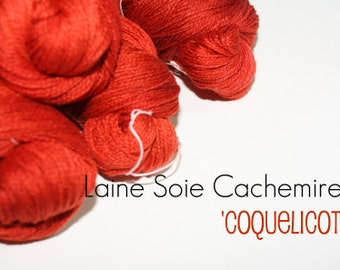 May include: Red yarn balls labeled "Laine Soie Cachemire 'Coquelicot'".