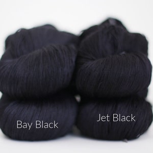 May include: Two skeins of black yarn, one labeled "Bay Black" and the other labeled "Jet Black".