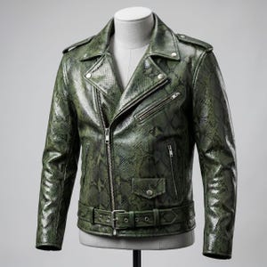 May include: A motorcycle jacket in a dark olive green with a textured snakeskin pattern. The jacket features a wide notched collar with silver-tone metal snaps, an asymmetrical front zipper, multiple zippered pockets, and a buckled waist belt.