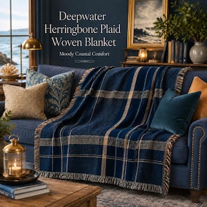 May include: A woven blanket featuring a deep blue and tan herringbone plaid pattern with fringed edges. The text on the image reads: Deepwater Herringbone Plaid Woven Blanket, Moody Coastal Comfort. The blanket is draped over a dark blue sofa.