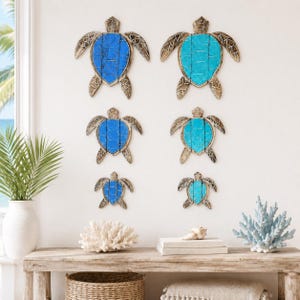 May include: A set of six wall-mounted sea turtle decorations arranged in two vertical columns. Each turtle features a weathered brown frame with a central shell panel in varying shades of blue and turquoise, accented by a wire grid pattern.