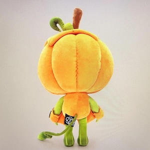 Pode incluir: Uma boneca de ab&oacute;bora de pel&uacute;cia com uma grande cabe&ccedil;a laranja, bra&ccedil;os e pernas verdes e uma longa cauda verde. A boneca tem um caule marrom e uma folha verde encaracolada no topo. Decora&ccedil;&atilde;o de Halloween.