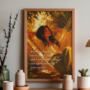 May include: A framed wall art print featuring an illustration of a person resting in a hammock under golden sunlight. The text reads: When we simplify our lives, we create space to breathe, connect and appreciate what truly matters. The frame is light wood.