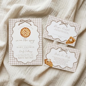 Puede incluir: Un conjunto de invitaciones para baby shower con un patrón de cuadros vichy marrón claro, un borde decorativo con un lazo e ilustraciones de tartas de manzana. El texto incluye A Little Cutie Pie is on the way, Diaper Raffle y Books for Baby.
