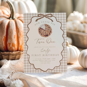 Puede incluir: Una tarjeta de invitación de cumpleaños rectangular con un patrón de cuadros vichy en beige y blanco. El centro presenta un marco festoneado marrón con un lazo, una ilustración de tarta y el texto: Our Cutie Pie Turns One, Join Us To Celebrate Emily's First Birthday.
