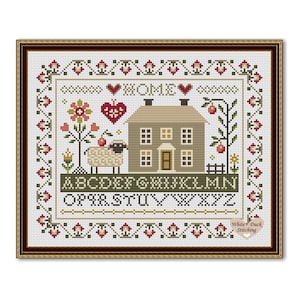 May include: Cross-stitch sampler featuring a house, sheep, and floral elements. The word "HOME" is stitched above the house, with the alphabet below. The design is framed with a floral border and a brown wooden frame.