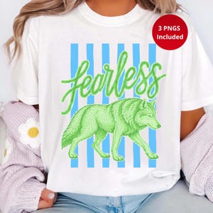 May include: White t-shirt featuring a green wolf illustration with the word "fearless" in a script font. The design includes blue vertical stripes. A red circle indicates that 3 PNGs are included.