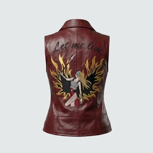 May include: Burgundy leather vest with a warrior graphic on the back. The graphic features a blonde-haired figure holding a spear, surrounded by gold flames. The text "Let me live" is embroidered above the graphic.
