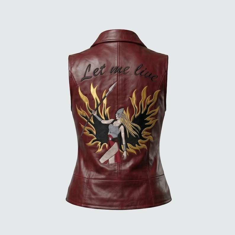 May include: Burgundy leather vest with a warrior graphic on the back. The graphic features a blonde-haired figure holding a spear, surrounded by gold flames. The text "Let me live" is embroidered above the graphic.