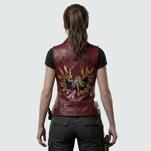 May include: A burgundy leather vest with a detailed embroidered design on the back. The design features a warrior figure with a sword, surrounded by flames, and the text "Let me live".