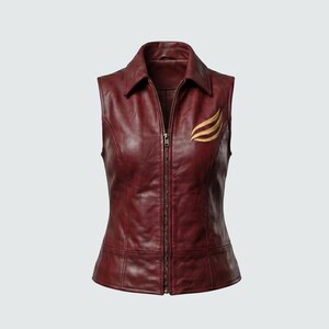 May include: A sleeveless burgundy leather vest with a collared neckline and a full-length zipper. The vest features a gold-colored emblem on the upper left chest. The vest is tailored with seams and has a fitted silhouette.
