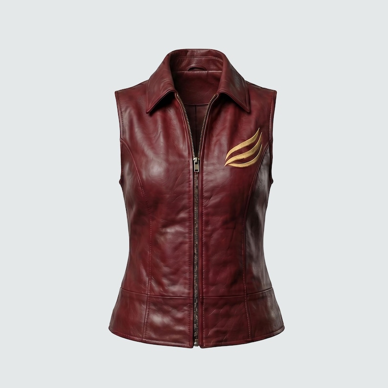 May include: A sleeveless burgundy leather vest with a collared neckline and a full-length zipper. The vest features a gold-colored emblem on the upper left chest. The vest is tailored with seams and has a fitted silhouette.